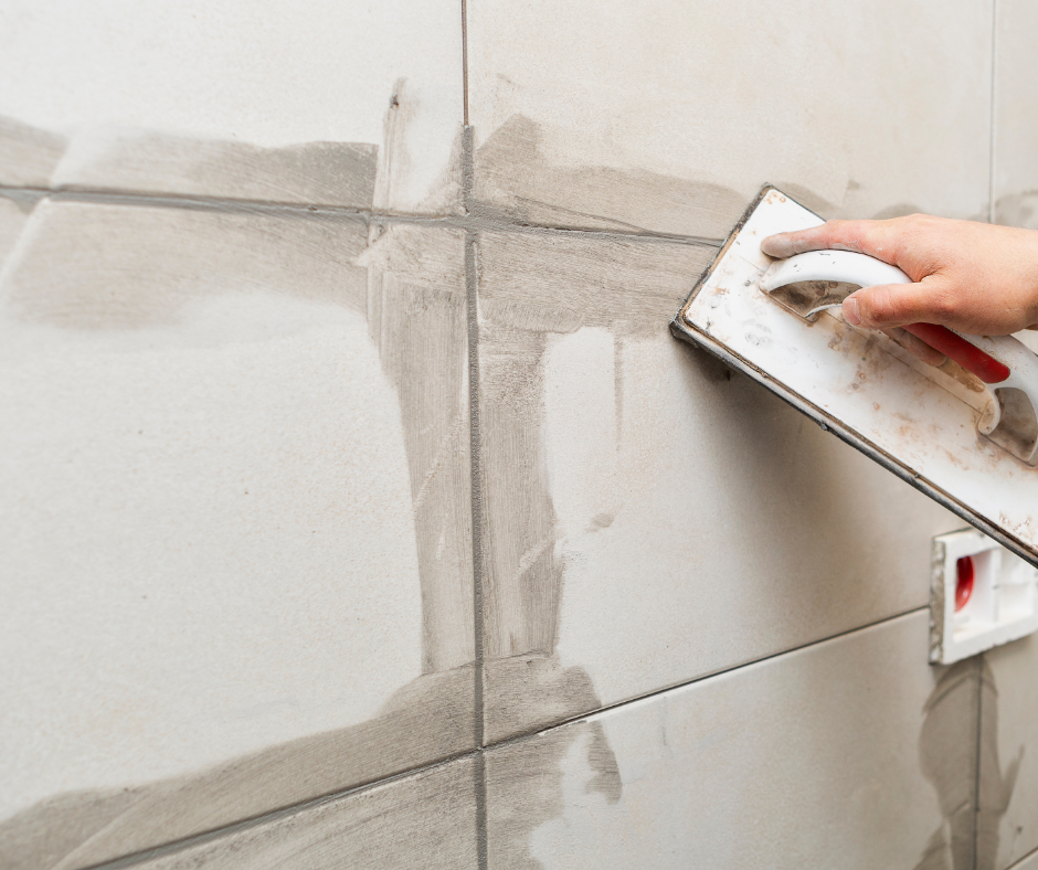 Thợ đang trét ron gạch mới để thay thế đường ron cũ bị đen mốc nặng.